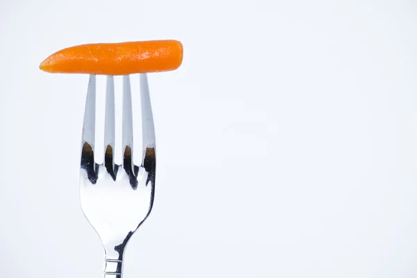 Διατροφή, δάγκωμα καρότο σε ένα πιρούνι — Φωτογραφία Αρχείου