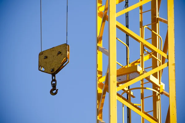 Gelber Kran gegen blauen Himmel, Turm mit Haken — Stockfoto