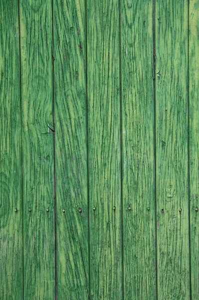 Green paint peeling from a wooden panel door. Aged texture — Stock Photo, Image
