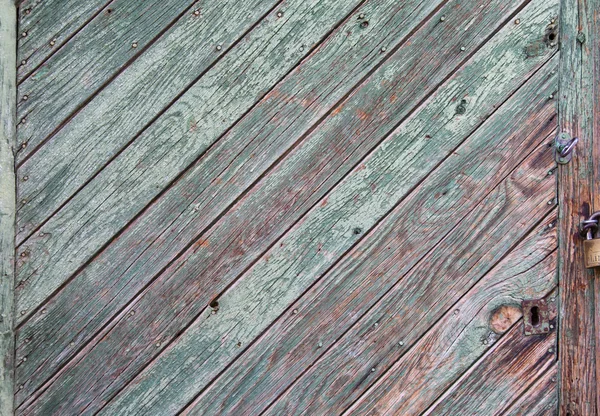 Зеленая краска, отслаивающаяся от двери деревянной панели, на которой изображен гр древесины — стоковое фото
