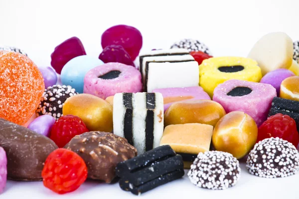 Molte caramelle su sfondo bianco. snack di frutta — Foto Stock