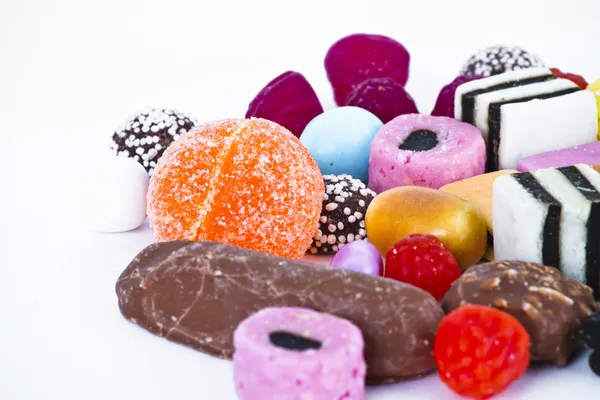 Mnoho cukroví na bílé background.candy barvy — Stock fotografie
