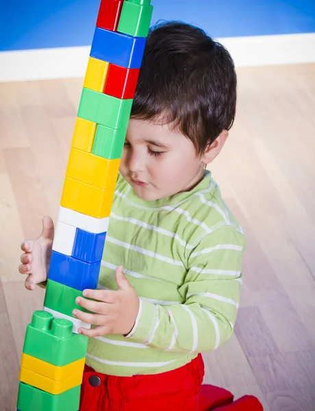 Menino (2 anos) brincando com blocos de brinquedo. Engraçado. — Fotografia de Stock