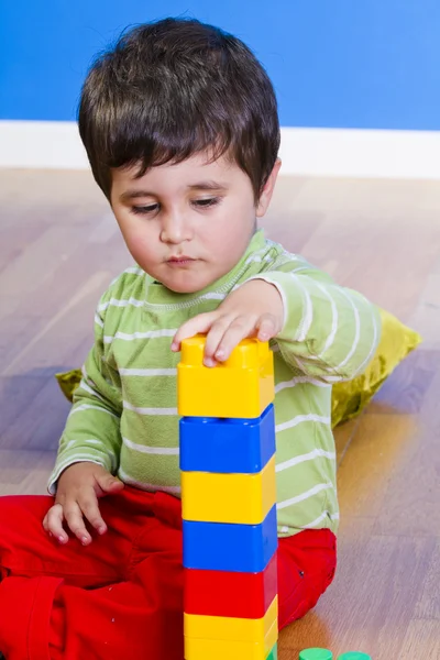 Menino (2 anos) brincando com blocos de brinquedo. Engraçado. — Fotografia de Stock