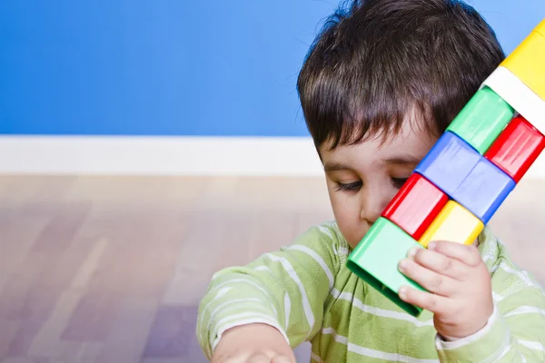 Funny little boy playing with plastic colorful blocks, studio sh — Stock Photo, Image