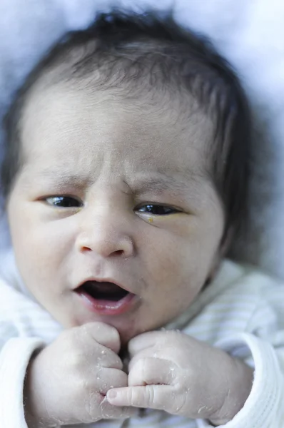 Pasgeboren baby glimlachend en spelen met zijn handen — Stockfoto
