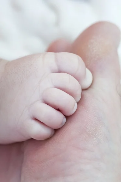 Neugeborener Fuß auf den Zehen seines Vaters — Stockfoto