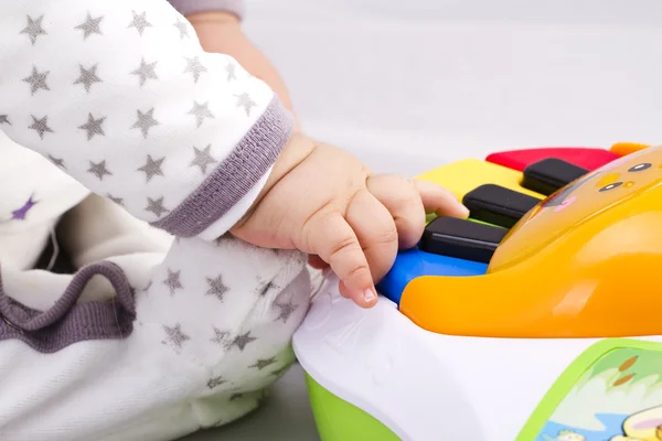 Newborn baby boy playing with a toy piano — Stock Photo, Image
