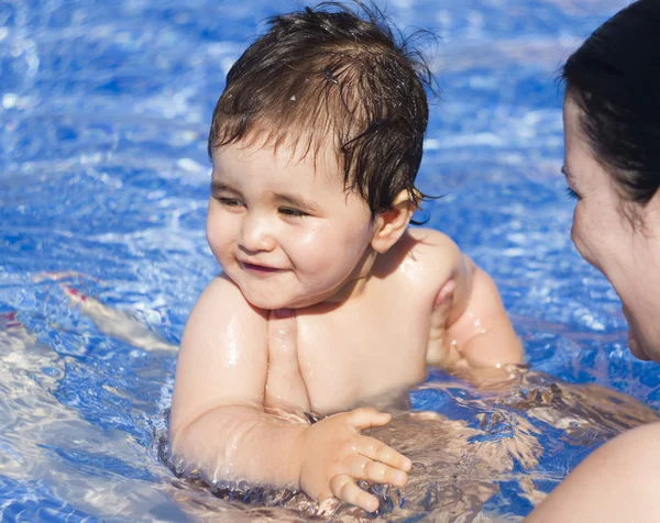 Новорожденный ребенок играет в бассейне со своей матерью — стоковое фото