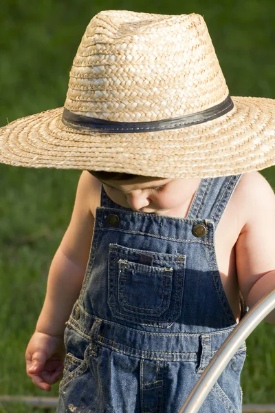 Хлопчик з солом'яним капелюхом, молодий садівник насолоджується весною — стокове фото