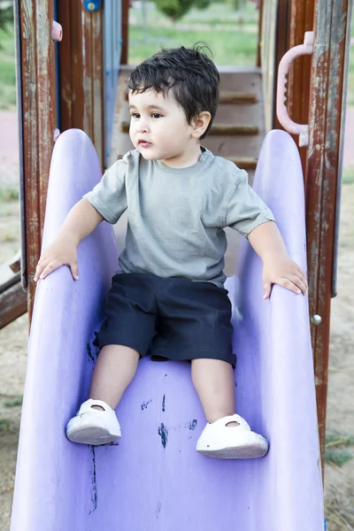 Lindo bebé jugando en el tablero deslizante —  Fotos de Stock