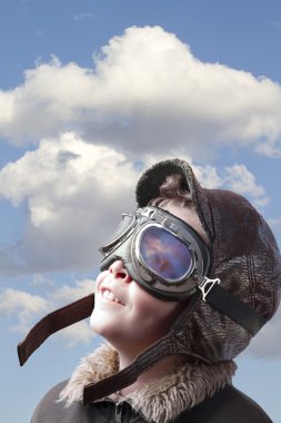 Boy dressed up in pilot outfit, jacket, hat and glasses. clipart
