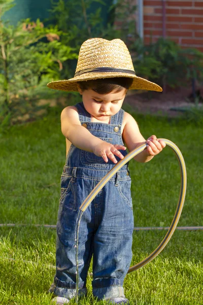 Little baby boy gardener playing with his back to the camera — Stock Photo, Image