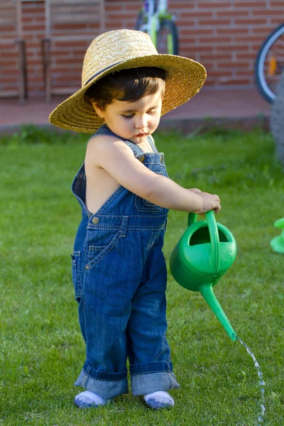 Маленький мальчик садовник играет на своем дворе — стоковое фото
