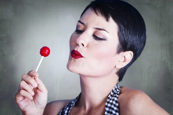 Portrait of lovely brunette with lolly pop, over rusty backgroun