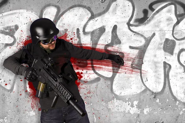 Truppe d'assalto, soldato ferito in azione, sfondo grafitti — Foto Stock