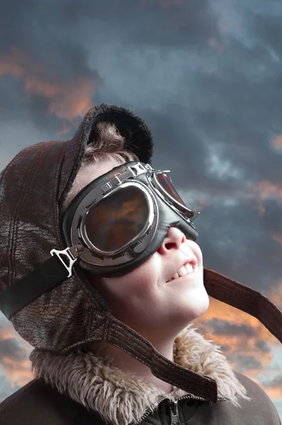 Мальчик играет с пилотной шляпой и облачным фоном — стоковое фото