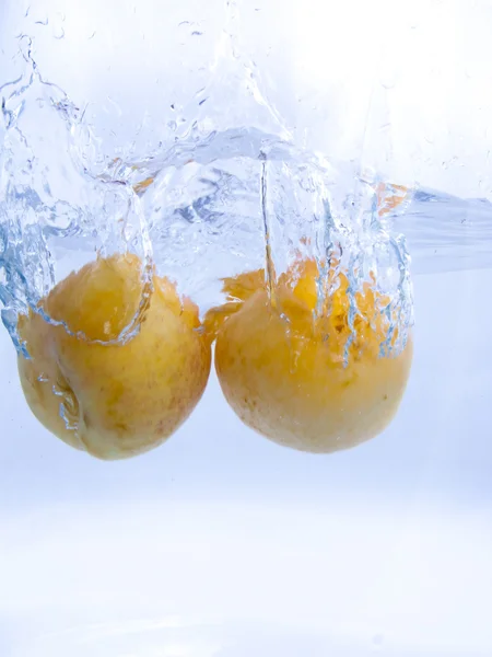 Frutas caindo na água — Fotografia de Stock