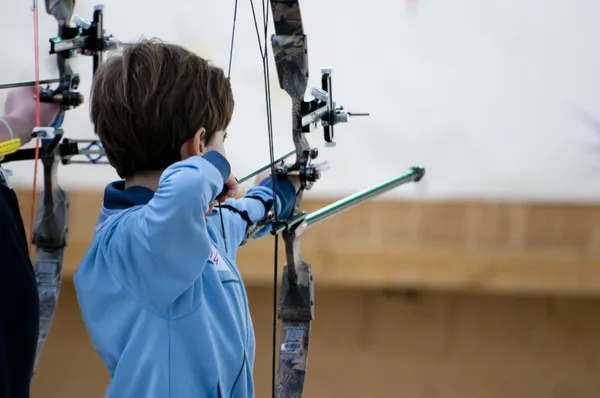 Мальчик, стоящий на ногах с луком и стрелами — стоковое фото