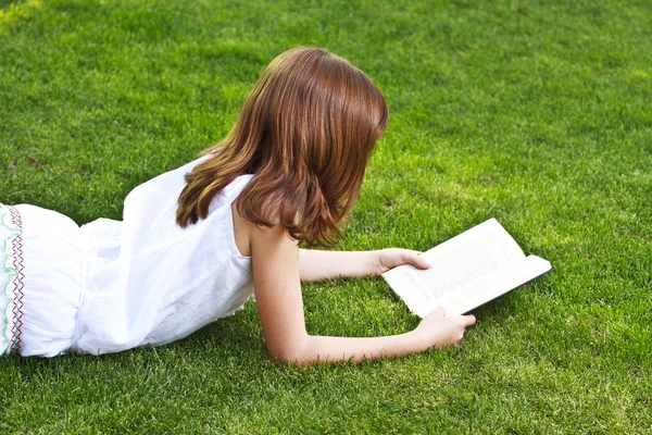 Молода красива дівчина читає книгу на відкритому повітрі — стокове фото