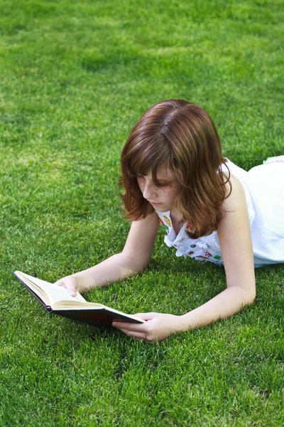 Jong mooi meisje lezen een boek outdoor — Stockfoto