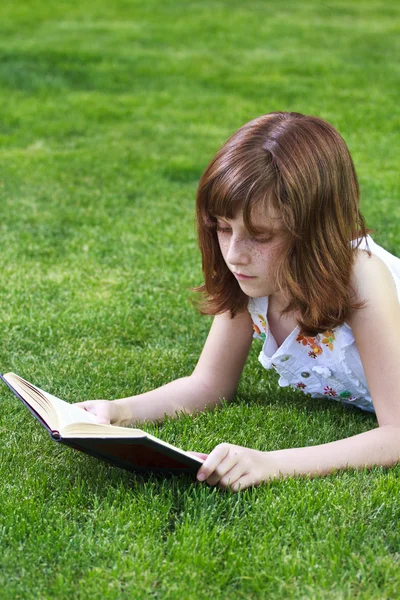 Jovem menina bonita lendo um livro ao ar livre — Fotografia de Stock