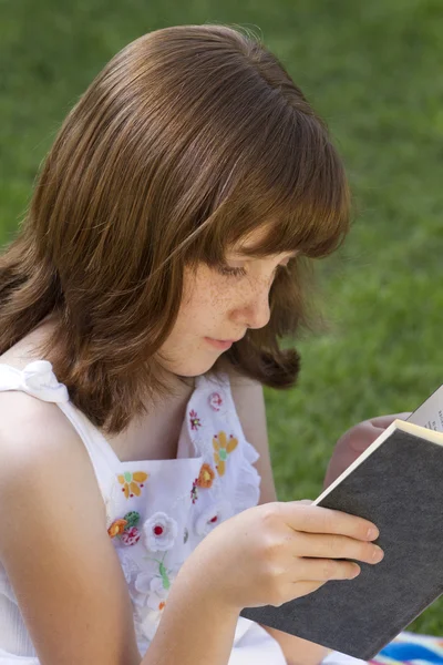 Jeune belle fille lisant un livre en plein air — Photo
