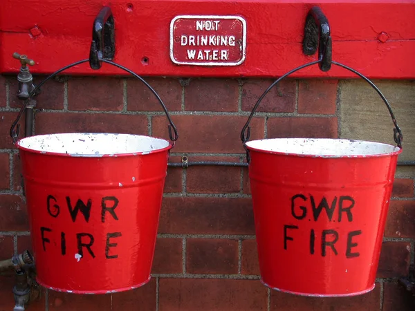 Deux seaux de feu suspendus sur un mur — Photo