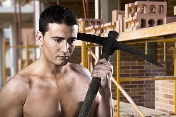 Mężczyzna robotnik z wybrać topór i cegieł — Zdjęcie stockowe
