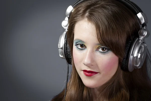 Girl in headphones on a dark grey background — Stock Photo, Image