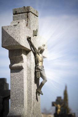 Jesus Christ on stone cross, cemetery scene with mystic rays of clipart