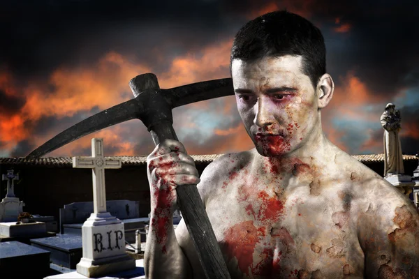 Male zombie in a cemetery, undertaker with pick axe — Stock Photo, Image