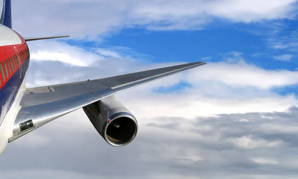 Airliner flying in high cloudy sky — Stock Photo, Image