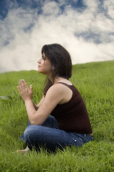 Frau sitzt auf Gras und betet — Stockfoto