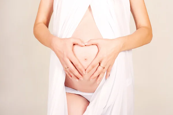 Detail van de zwangere vrouw die hart vormen met handen — Stockfoto