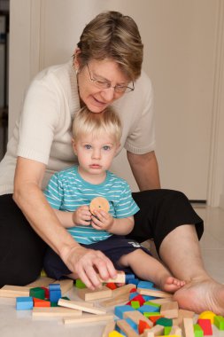 A little boy plays with his grandmother clipart