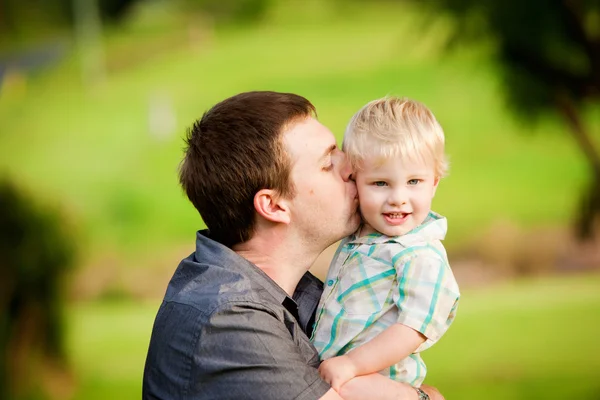 Un bambino gioca con suo padre in un campo all'aperto — Foto Stock