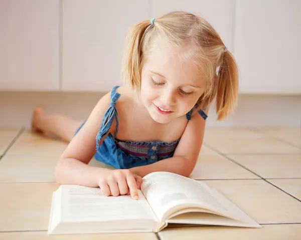 Маленькая четырехлетняя девочка читает — стоковое фото