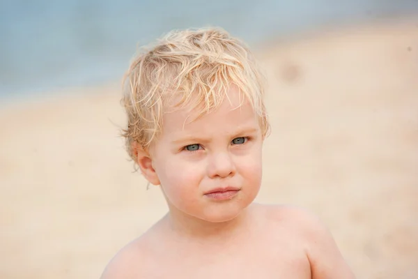 Trochę blond włosy, niebieskie oczach jeden-letni chłopak na plaży. — Zdjęcie stockowe