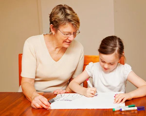 A little girl drawing with her carer — Stock Photo, Image
