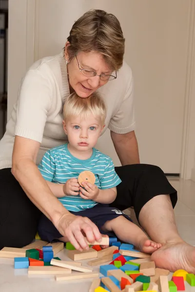 A little boy plays with his grandmother — Stock Photo, Image