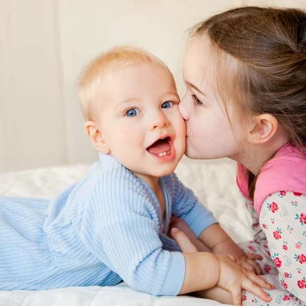 Starsza siostra całuje jej młodszy brat Obrazek Stockowy