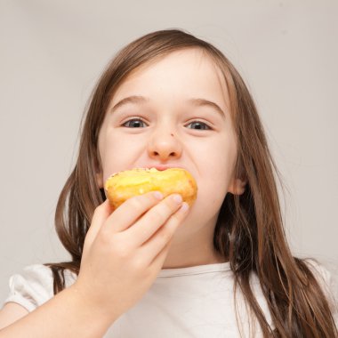 genç bir kız bir donut yiyor