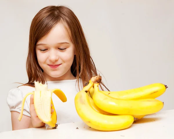 Mladá dívka jí banány — Stock fotografie