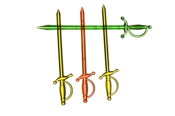 Три пластиковых меча поверх зелёного. — стоковое фото
