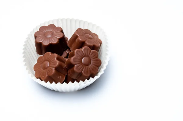 Daisy shaped chocholate assortments in a paper basket — Stock Photo, Image