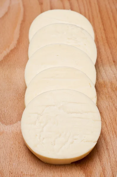 行の丸いチーズをスライスします。 — ストック写真