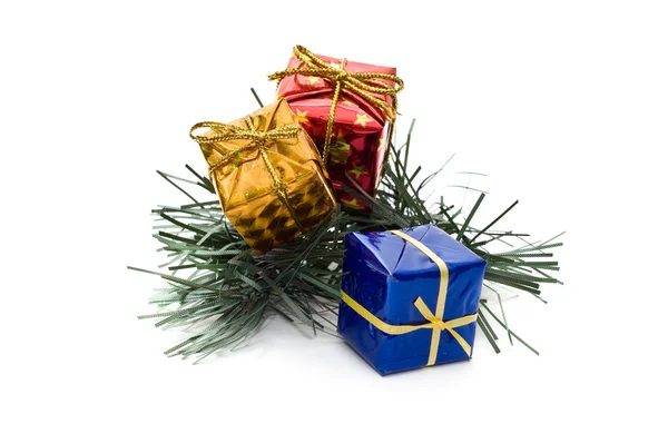 Three small gift boxes on pine branch — Stock Photo, Image