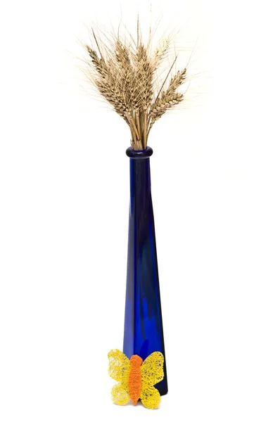 Bündel Weizenspitzen in blauer Vase mit einem gelben Schmetterling — Stockfoto