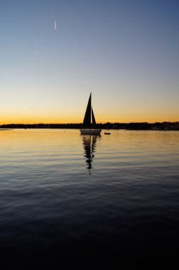 Sailboat mooring at sunset clipart